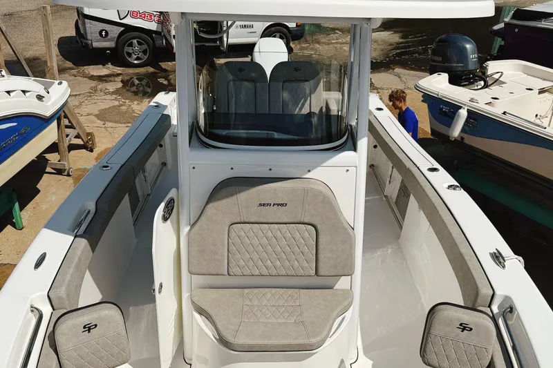 Slide: The Image of 2023 Sea Pro 239 DLX boat interior with cushioned seating and console. - 22