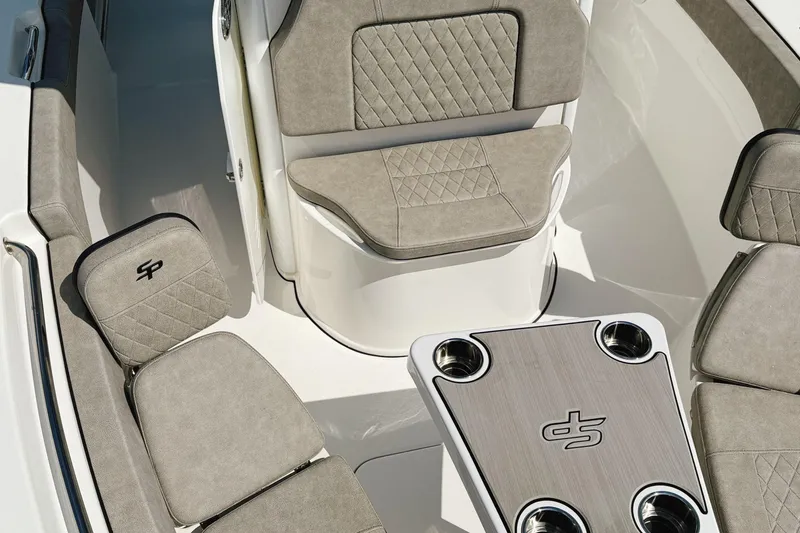 Slide: The Image of 2023 Sea Pro 239 DLX boat interior with cushioned seating and table. - 23