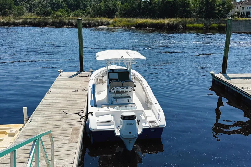Slide: The Image of 2023 Sea Pro 239 DLX boat docked on a calm river. - 3