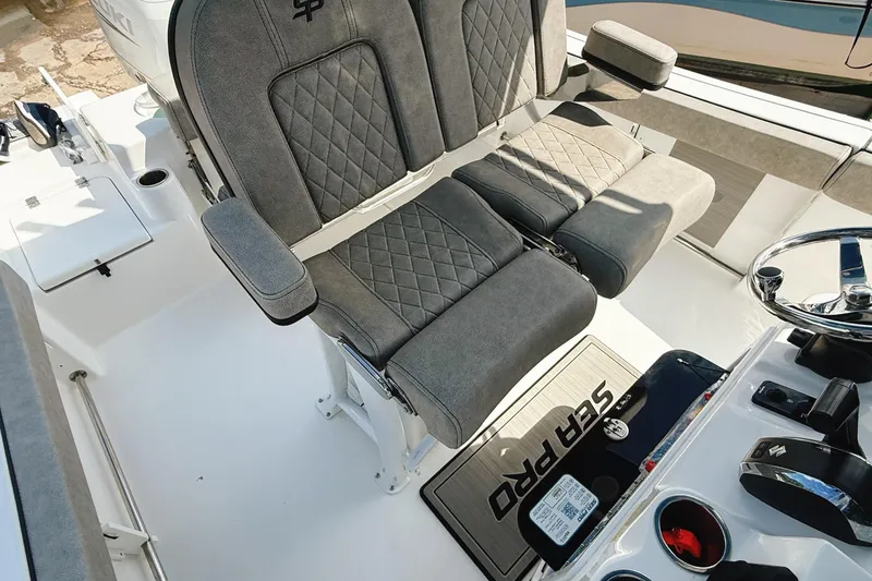Slide: The Image of 2023 Sea Pro 239 DLX boat interior with plush seating and steering console. - 33