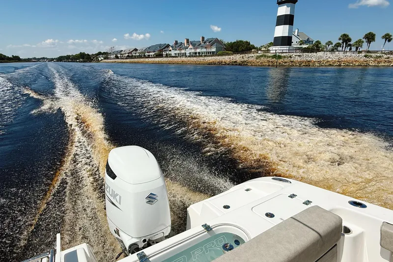 Slide: The Image of 2023 Sea Pro 239 DLX boat cruising near a lighthouse on a sunny day. - 36