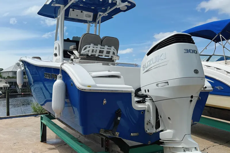 Slide: The Image of 2023 Sea Pro 239 DLX boat with Suzuki 300 engine, docked under blue sky. - 5