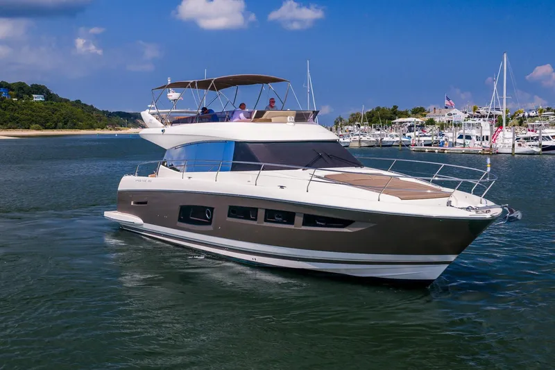 The Image of 2014 Prestige Yachts 550 Flybridge cruising in a marina with scenic background. - 0