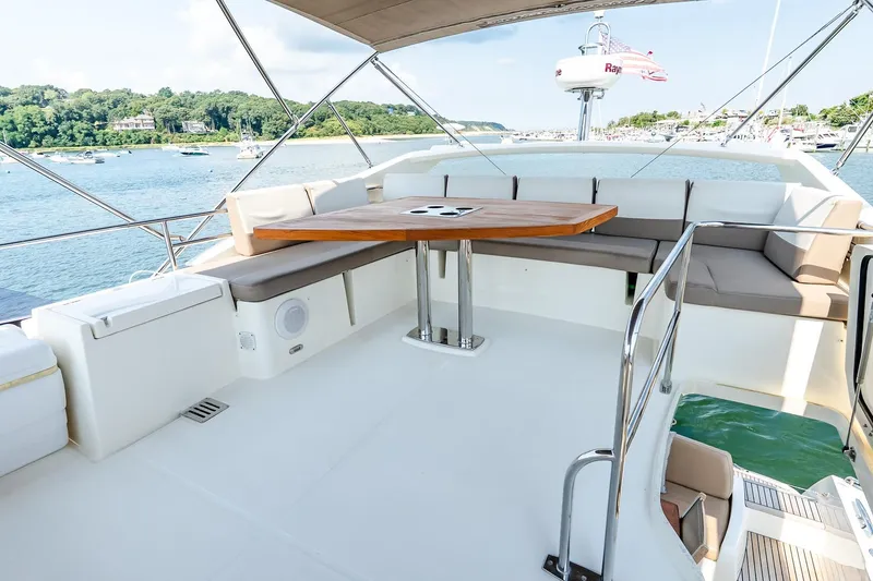 Slide: The Image of Flybridge of 2014 Prestige Yachts 550, featuring spacious seating and a wooden table. - 10
