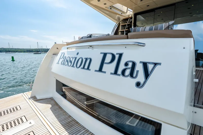 Slide: The Image of 2014 Prestige Yachts 550 Flybridge named "Passion Play" docked by the water. - 12