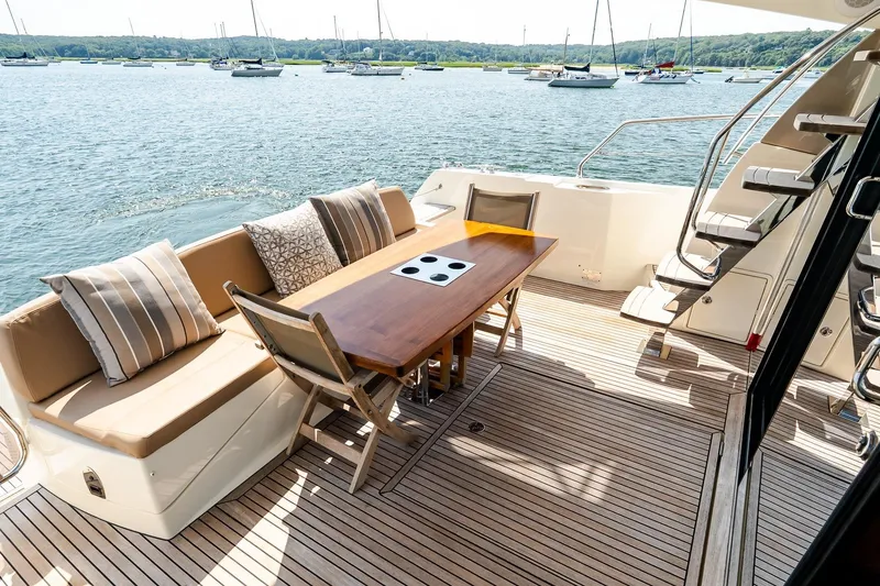 Slide: The Image of Luxurious 2014 Prestige Yachts 550 Flybridge deck with seating, table, and scenic water view. - 14