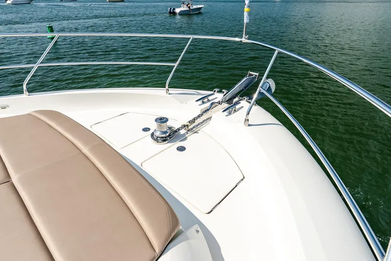 Slide: The Image of Prestige Yachts 550 Flybridge 2014, bow view with sunpad and anchor, on calm water. - 17