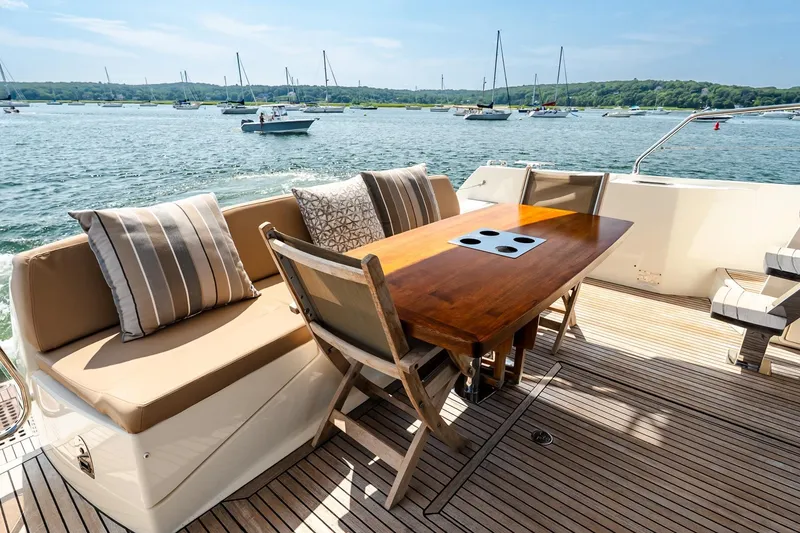 Slide: The Image of Luxurious 2014 Prestige Yachts 550 Flybridge deck with seating and table, overlooking serene waters. - 19