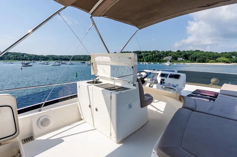 Slide: The Image of Flybridge of 2014 Prestige Yachts 550, overlooking serene waters and distant shoreline. - 23
