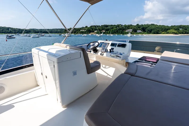 Slide: The Image of Flybridge of 2014 Prestige Yachts 550, overlooking serene waters and distant boats. - 24