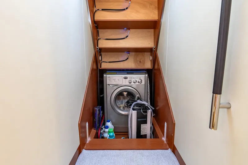 Slide: The Image of Laundry area on 2014 Prestige Yachts 550 Flybridge with washing machine and storage shelves. - 37