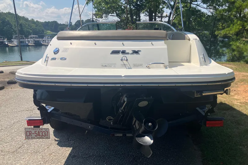 Slide: The Image of 2013 Sea Ray 210 SLX boat on trailer, parked near a lake. - 15