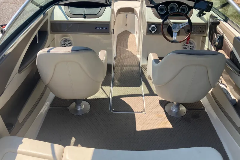Slide: The Image of Interior of a 2013 Sea Ray 210 SLX boat with beige seating and dashboard. - 17