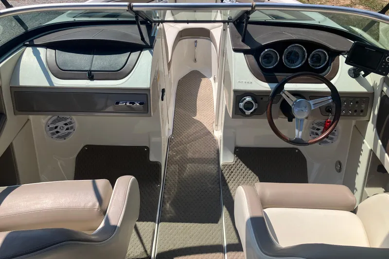 Slide: The Image of Interior of a 2013 Sea Ray 210 SLX boat, featuring steering wheel and dashboard. - 18