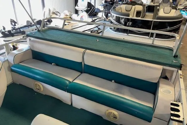 Slide: The Image of 1997 Crest Sport boat interior with teal and white seating, showcasing spacious design. - 11