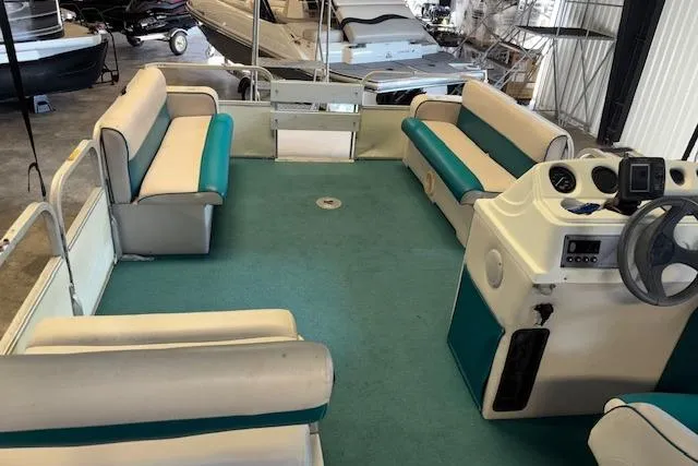 Slide: The Image of 1997 Crest Sport pontoon boat interior with teal and white seating, steering console, and spacious layout. - 12