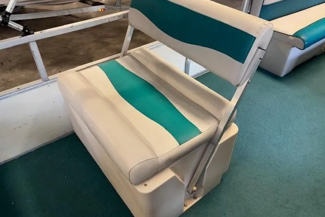 Slide: The Image of 1997 Crest Sport boat seat with teal and white upholstery on a teal carpeted floor. - 13