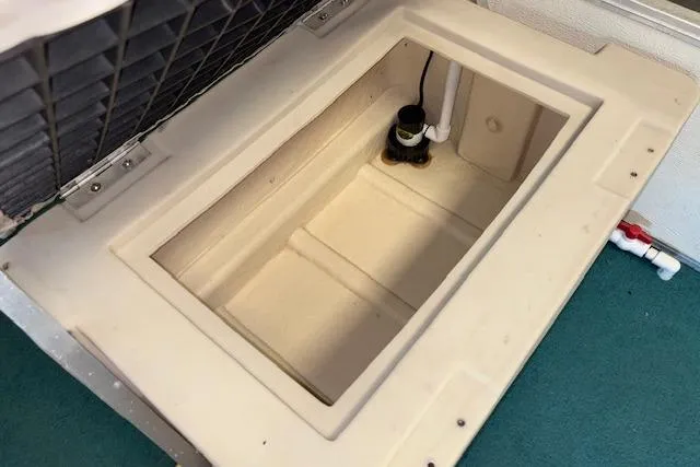 Slide: The Image of 1997 Crest Sport boat storage compartment with plumbing components. - 14