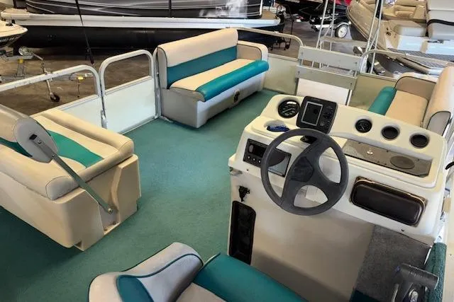 Slide: The Image of Interior of a 1997 Crest Sport boat with teal and white seating and steering console. - 15