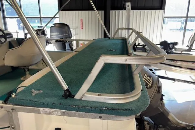 Slide: The Image of 1997 Crest Sport boat interior with green carpet and metal railing. - 19