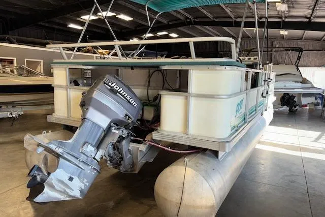 Slide: The Image of 1997 Crest Sport pontoon boat with Johnson outboard motor in a storage facility. - 4