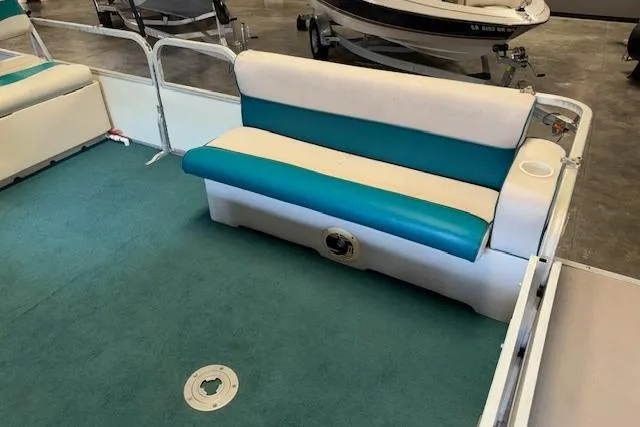 Slide: The Image of 1997 Crest Sport boat interior with teal and white seating, carpeted floor, and cup holder. - 7