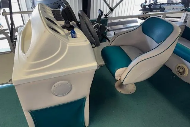 Slide: The Image of 1997 Crest Sport boat interior with steering console and teal cushioned seat. - 9