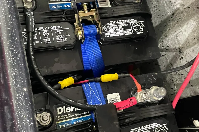Slide: The Image of Battery setup in a 2021 Phoenix 21 PHX boat with cables and safety labels. - 11