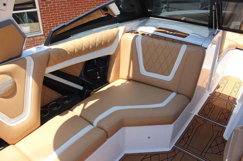 Slide: The Image of 2021 Tigé 23ZX boat interior with tan and white seating, stylish design, and cup holders. - 12