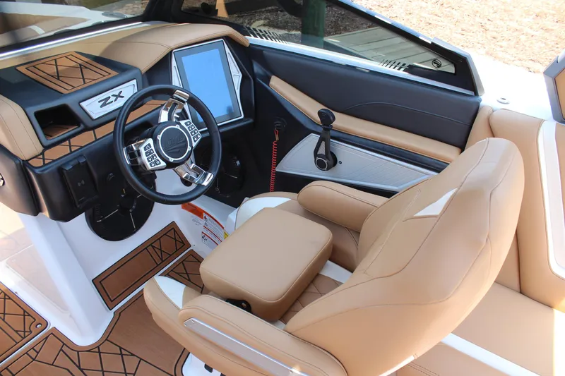 Slide: The Image of 2021 Tigé 23ZX boat interior with tan leather seats and modern dashboard. - 13