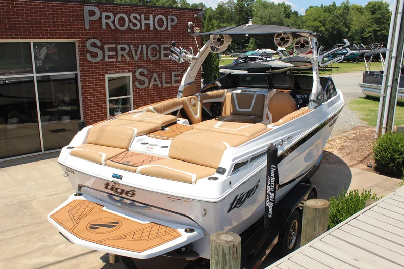 Slide: The Image of 2021 Tigé 23ZX boat displayed at a pro shop, featuring sleek design and tan seating. - 5