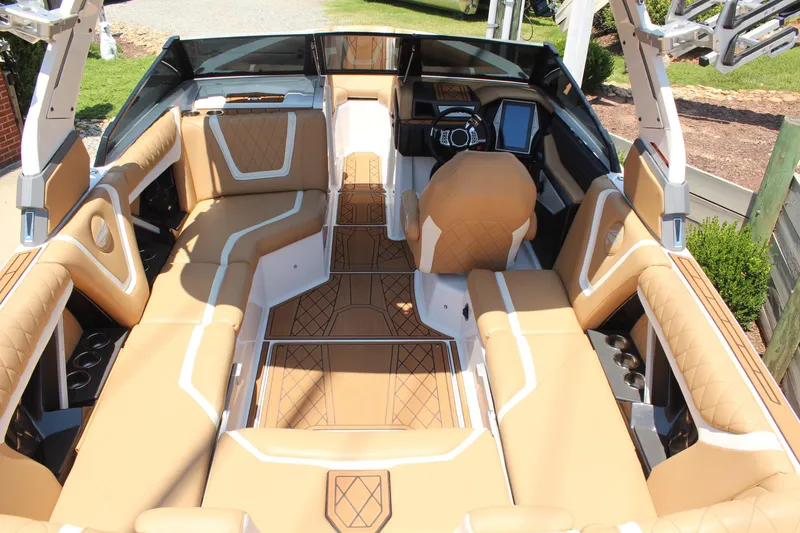 Slide: The Image of 2021 Tigé 23ZX boat interior with tan upholstery and modern dashboard. - 9
