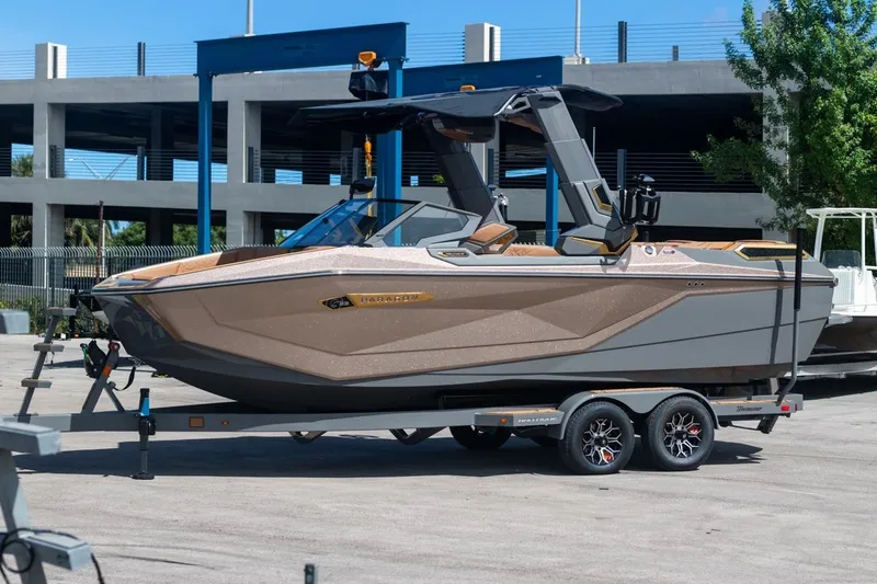 Slide: The Image of 2024 Nautique Super Air Nautique G23 Paragon boat on trailer, parked outdoors. - 0