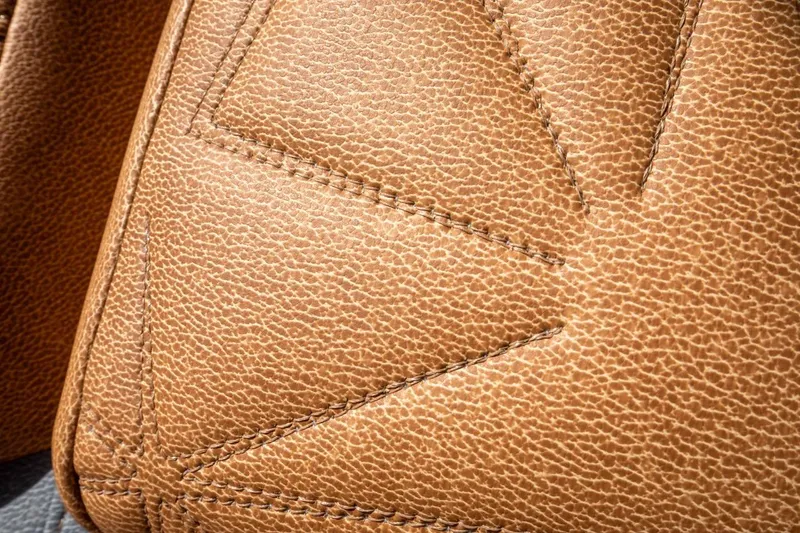 Slide: The Image of Close-up of brown leather upholstery with detailed stitching, 2024 Nautique Super Air Nautique G23 Paragon. - 3