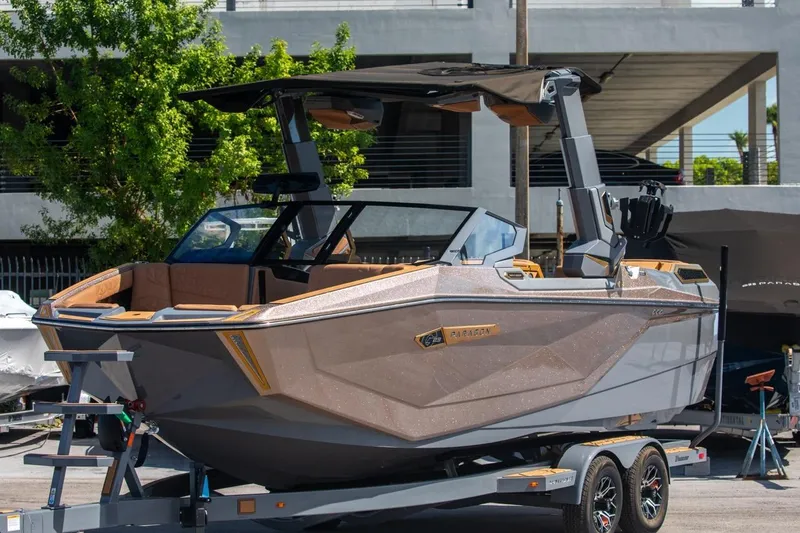 Slide: The Image of 2024 Nautique Super Air Nautique G23 Paragon boat on trailer, sleek design, outdoor setting. - 34