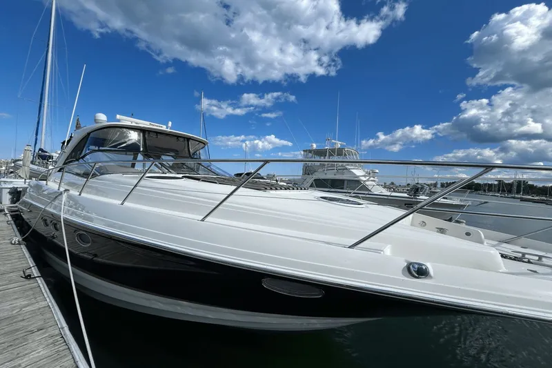 Slide: The Image of 2005 Regal Commodore 4260 yacht docked under a vibrant blue sky. - 1