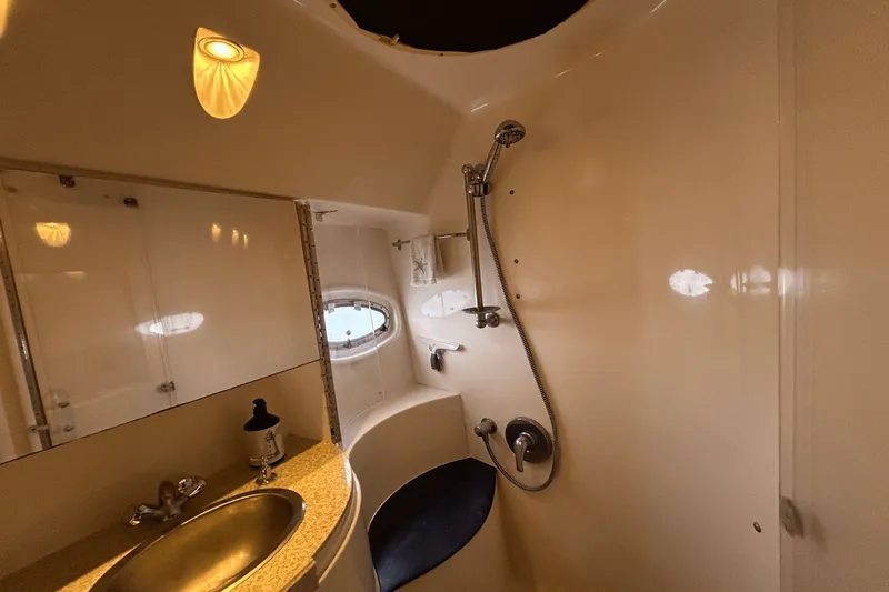 Slide: The Image of 2005 Regal Commodore 4260 yacht bathroom with shower, sink, and porthole window. - 25
