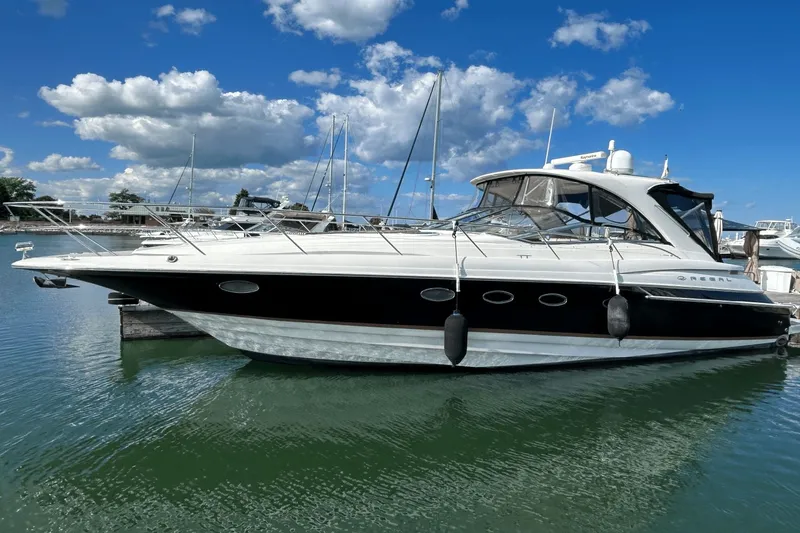 Slide: The Image of 2005 Regal Commodore 4260 yacht docked in a marina under a blue sky. - 3