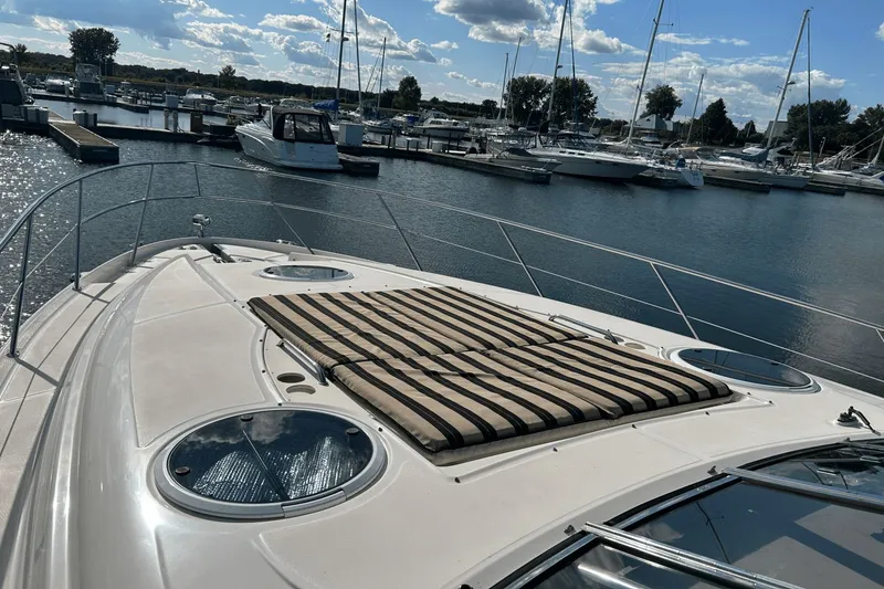Slide: The Image of 2005 Regal Commodore 4260 yacht docked at marina under blue sky. - 33