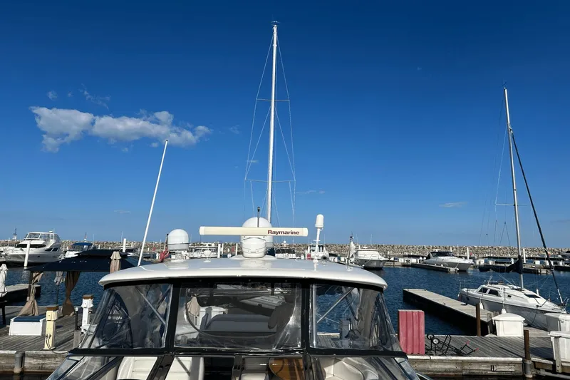 Slide: The Image of 2005 Regal Commodore 4260 yacht docked at marina under clear blue sky. - 36