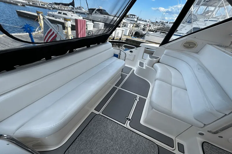 Slide: The Image of 2005 Regal Commodore 4260 yacht interior with white seating, docked at marina. - 4