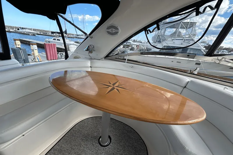 Slide: The Image of Interior of 2005 Regal Commodore 4260 yacht with wooden table and marina view. - 8