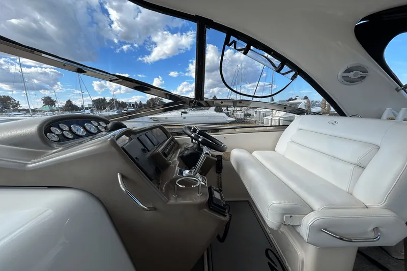 Slide: The Image of Interior of 2005 Regal Commodore 4260 yacht with white seating and control panel. - 9