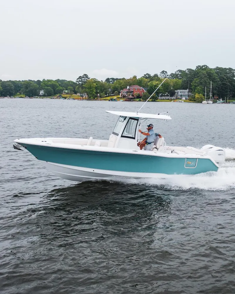 Slide: The Image of 2026 Sea Hunt Ultra 275 SE boat cruising on a lake with trees in the background. - 43