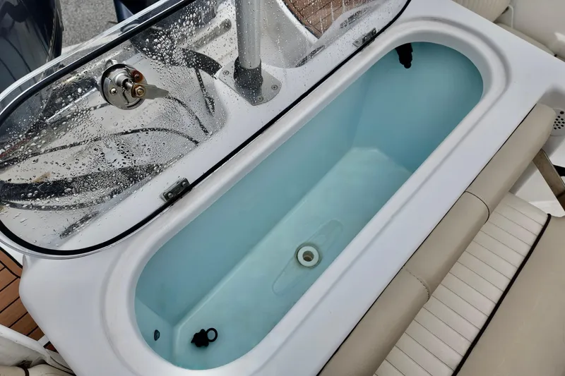 Slide: The Image of Livewell on a 2018 Sea Fox 266 Commander boat, featuring a clear lid and seating area. - 13