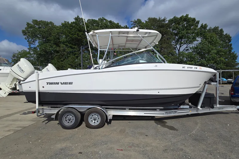 The Image of 2020 Twin Vee 240 DC GF boat on trailer, parked outdoors under cloudy sky. - 0
