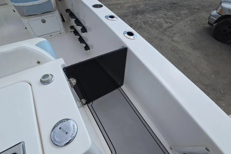 Slide: The Image of 2020 Twin Vee 240 DC GF boat interior, featuring seating and storage compartments. - 30