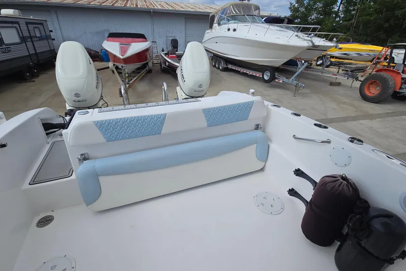 Slide: The Image of 2020 Twin Vee 240 DC GF boat interior with dual engines and seating, parked in a marina. - 34