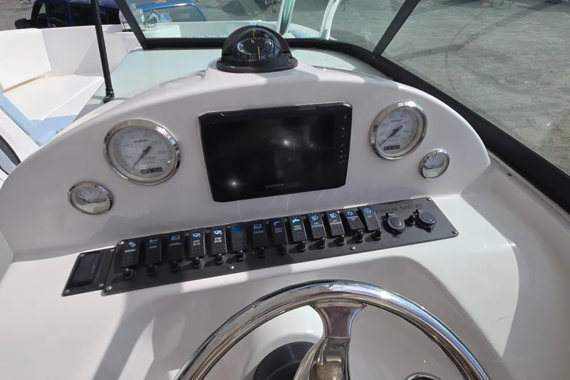 Slide: The Image of 2020 Twin Vee 240 DC GF boat dashboard with gauges, controls, and steering wheel. - 40