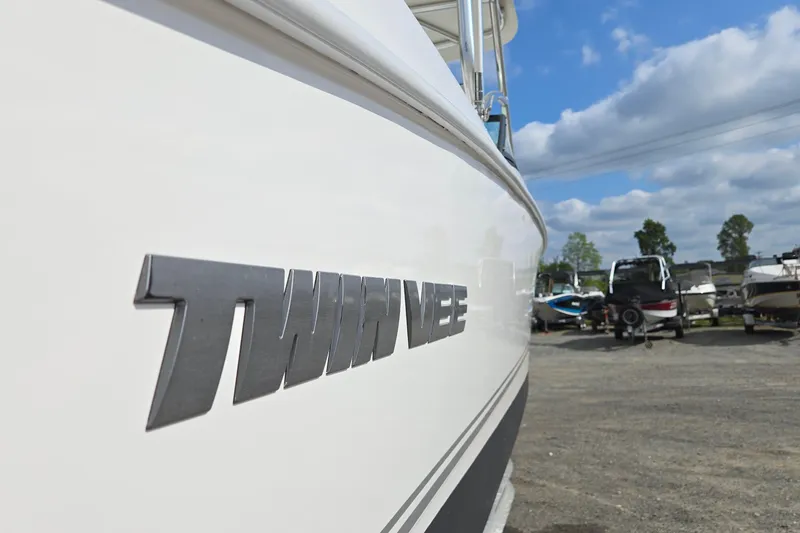 Slide: The Image of 2020 Twin Vee 240 DC GF boat side view with logo, parked outdoors. - 8